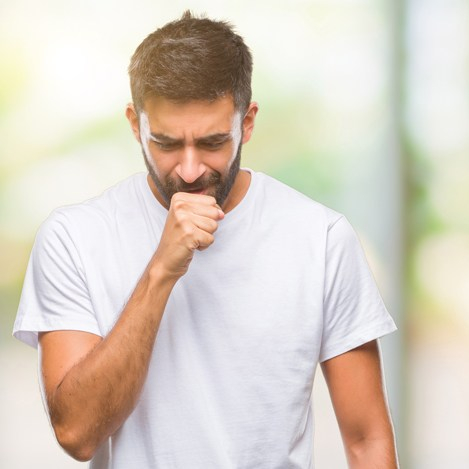 Sick man coughing into fist